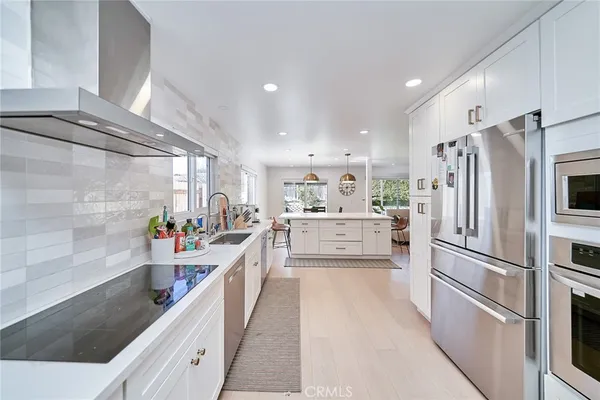 a kitchen with stainless steel appliances a refrigerator sink and white cabinets