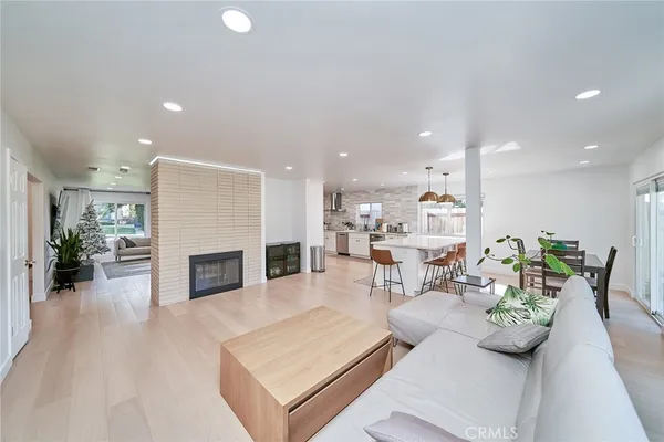 a living room with furniture fireplace and kitchen view