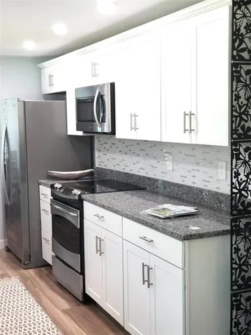 a kitchen with stainless steel appliances granite countertop a sink and a stove