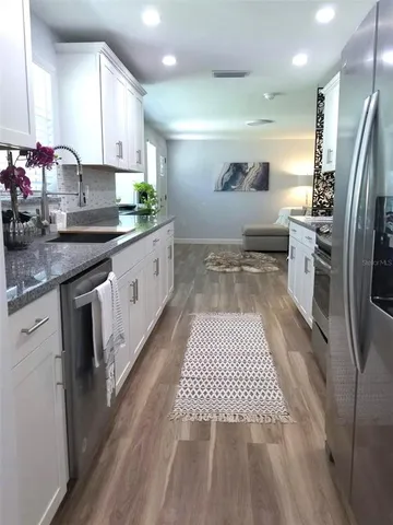 a kitchen with stainless steel appliances granite countertop a refrigerator and a stove top oven