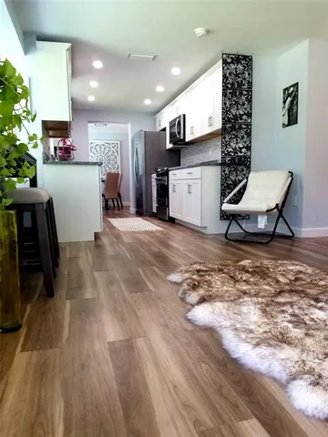 a view of a kitchen with furniture and wooden floor