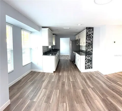 a view of a kitchen with wooden floor and a window