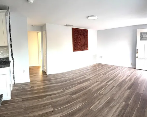 a view of empty room with wooden floor