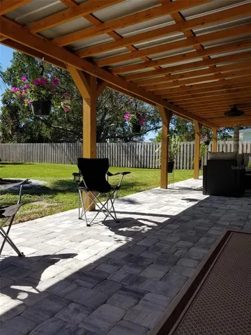 a view of a patio with a table and chairs with wooden fence