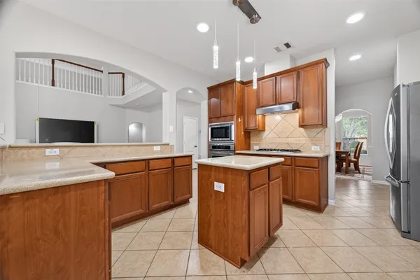a kitchen with stainless steel appliances granite countertop wooden cabinets a sink and dishwasher