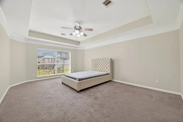 a spacious bedroom with a bed and a chandelier