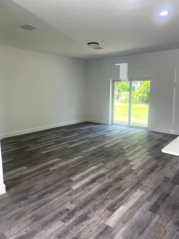 1683 Southwest 3rd Street Ocala, FL 34471 - Photo 8 of 14 a view of an empty room with wooden floor and a window