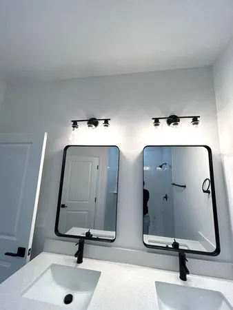 a bathroom with double vanity sinks and two mirror