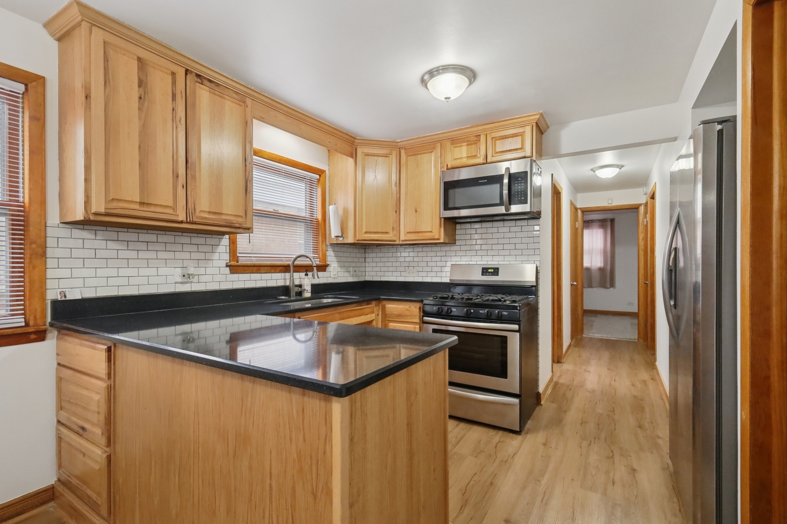1711 West 43rd Street Chicago, IL 60609 - Photo 6 of 25 a kitchen with stainless steel appliances granite countertop a sink a stove and a refrigerator