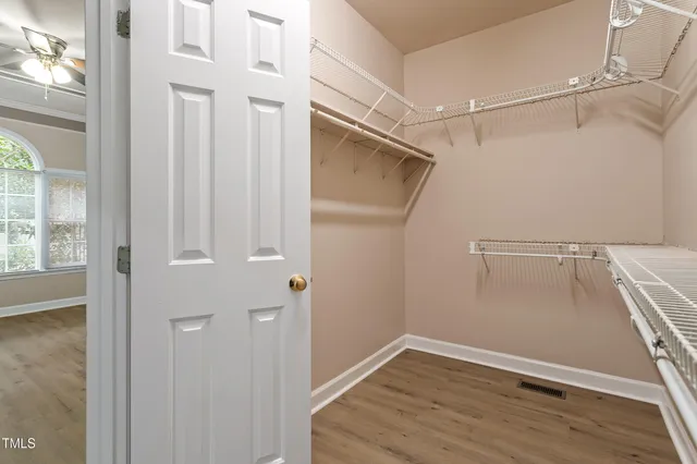 a view of walk in closet with empty racks