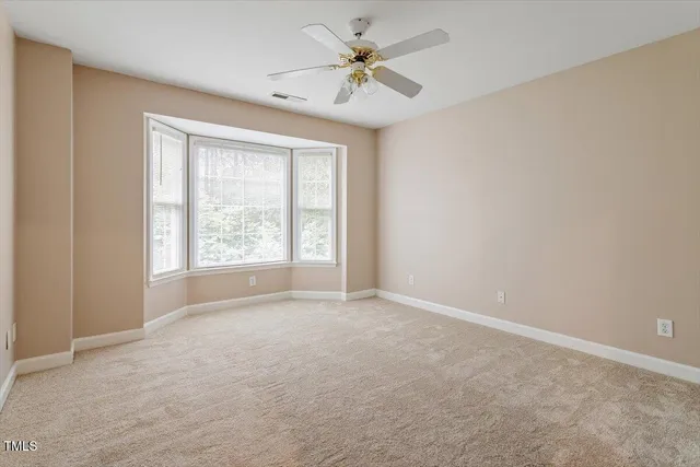 an empty room with windows and ceiling fan