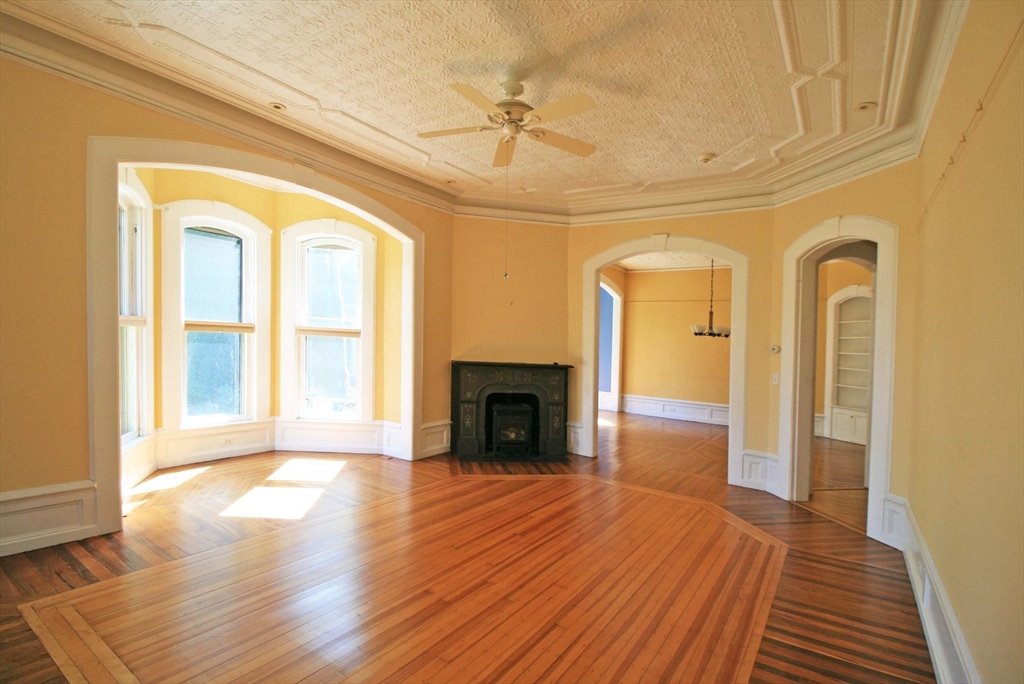 76 Crescent Street, Unit 2 Northampton, MA 01060 - Photo 4 of 25 a view of a livingroom with wooden floor a fireplace and windows