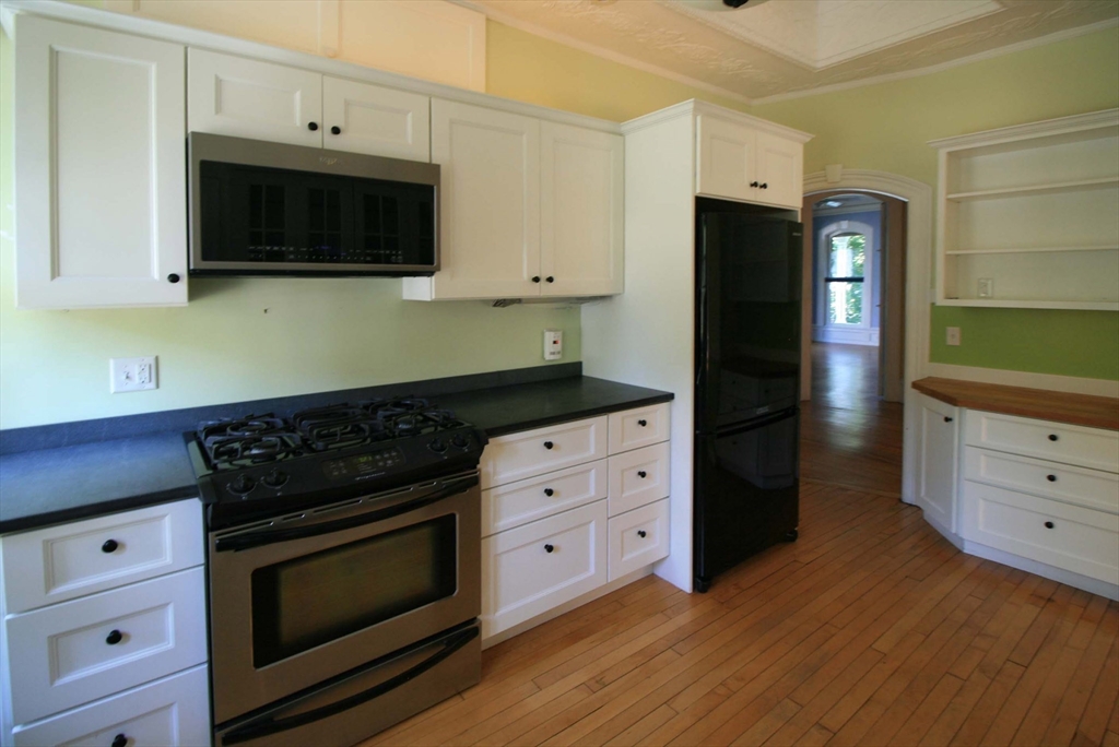 76 Crescent Street, Unit 2 Northampton, MA 01060 - Photo 6 of 25 a kitchen with stainless steel appliances white cabinets and a stove a oven with wooden floor
