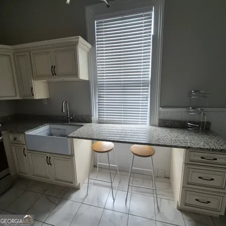 a kitchen with a sink a table and chairs