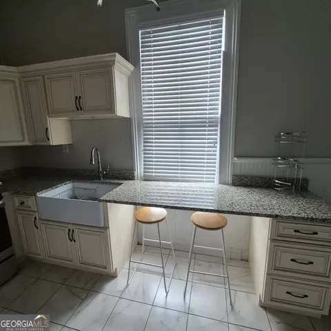 a kitchen with a sink a table and chairs