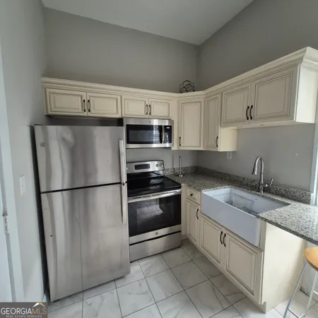 a kitchen with stainless steel appliances granite countertop a refrigerator sink and stove