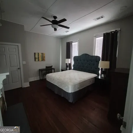 a bedroom with a bed lamps and a mirror on the dresser