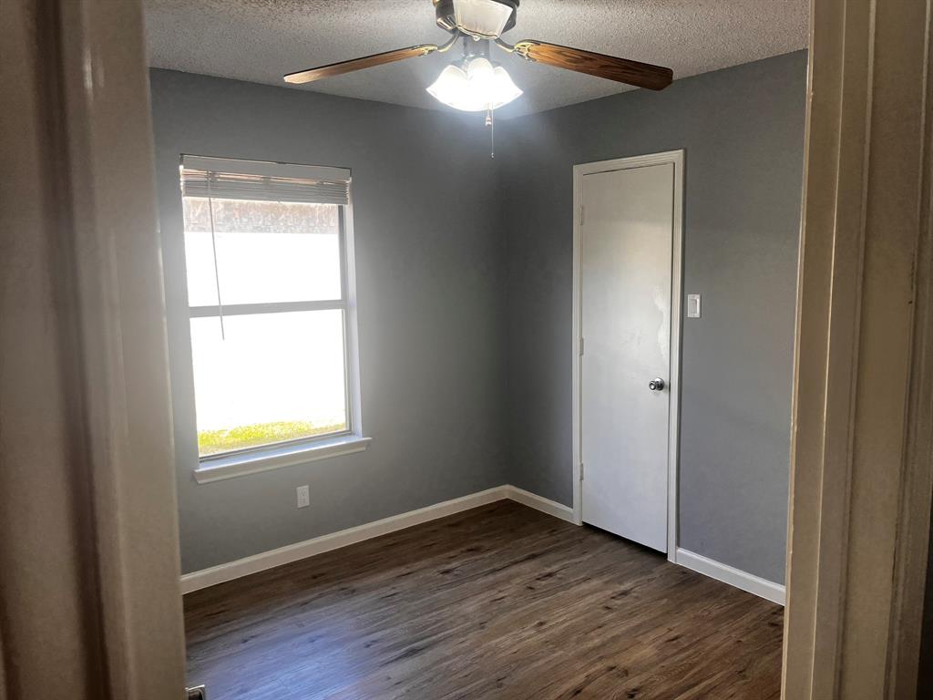 1007 Mack Place Denton, TX 76209 - Photo 32 of 37 Spare room featuring a ceiling fan, a textured ceiling, and dark wood-style flooring