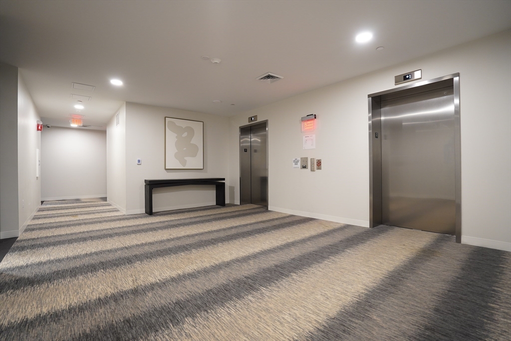 289 Walk Hill Street, Unit 301 Boston, MA 02131 - Photo 14 of 29 a view of a hallway with wooden floor and a fireplace