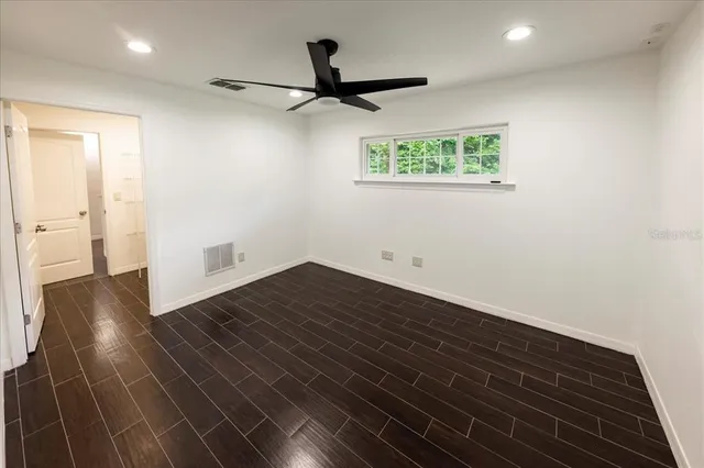 a view of an empty room with wooden floor