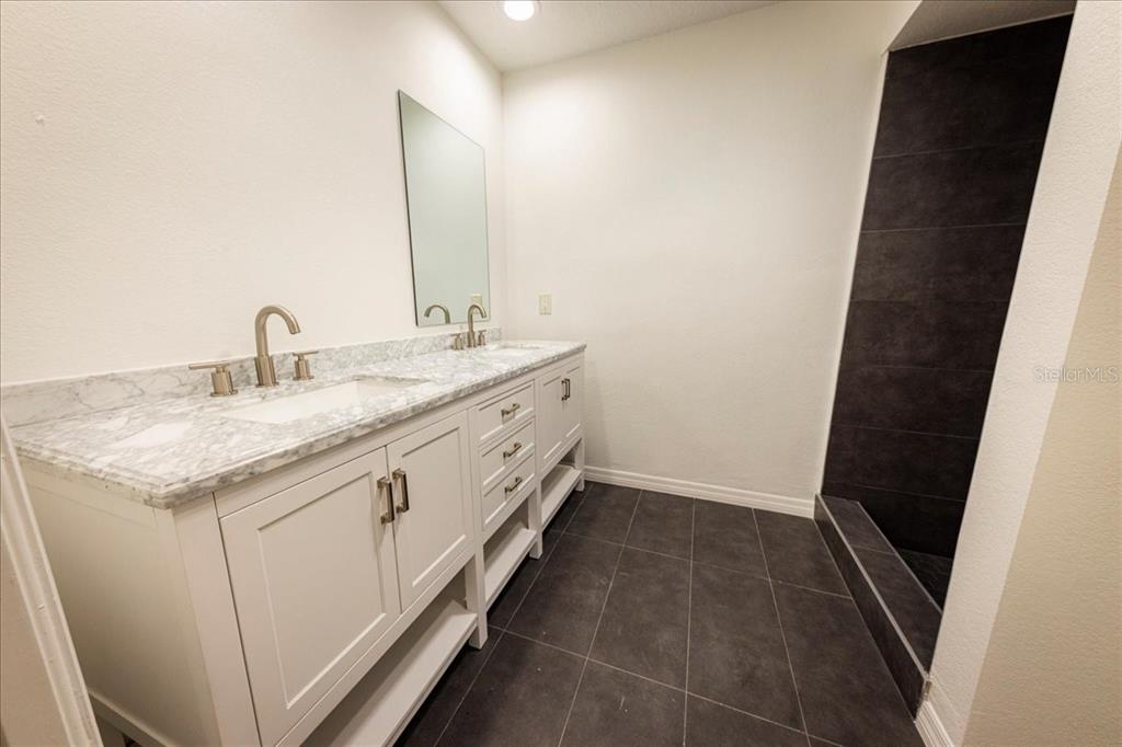 3443 Wild Myrtle Court Windermere, FL 34786 - Photo 22 of 32 a bathroom with a granite countertop sink and a mirror