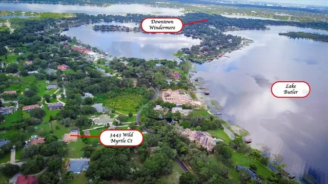 an aerial view of a residential house with outdoor space and trees all around