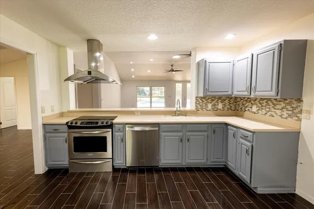 a kitchen with stainless steel appliances a stove a sink and a refrigerator