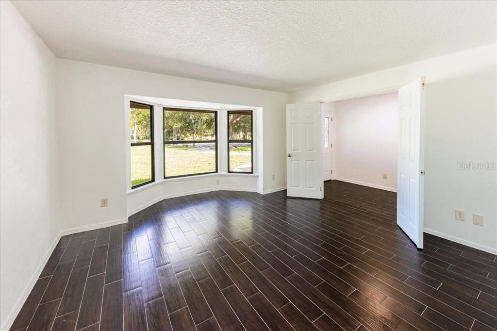 3443 Wild Myrtle Court Windermere, FL 34786 - Photo 8 of 32 a view of an empty room with wooden floor and a window
