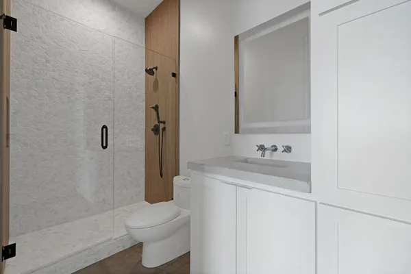 a bathroom with a sink a toilet and shower