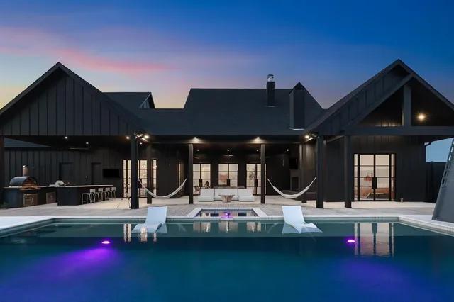 a view of a house with swimming pool and sitting area