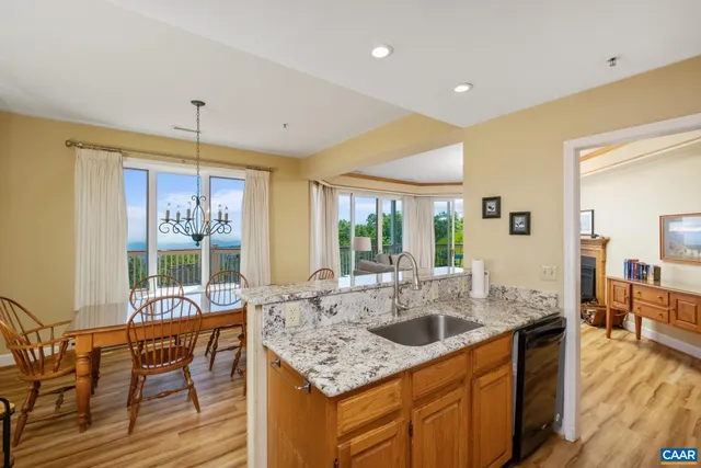 a kitchen with granite countertop a sink a counter top space and living room view