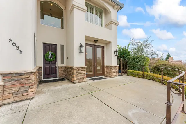 a view of an empty room with chandelier and glass door