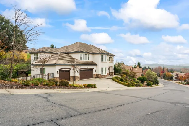a view of a white house with a large space in front of it
