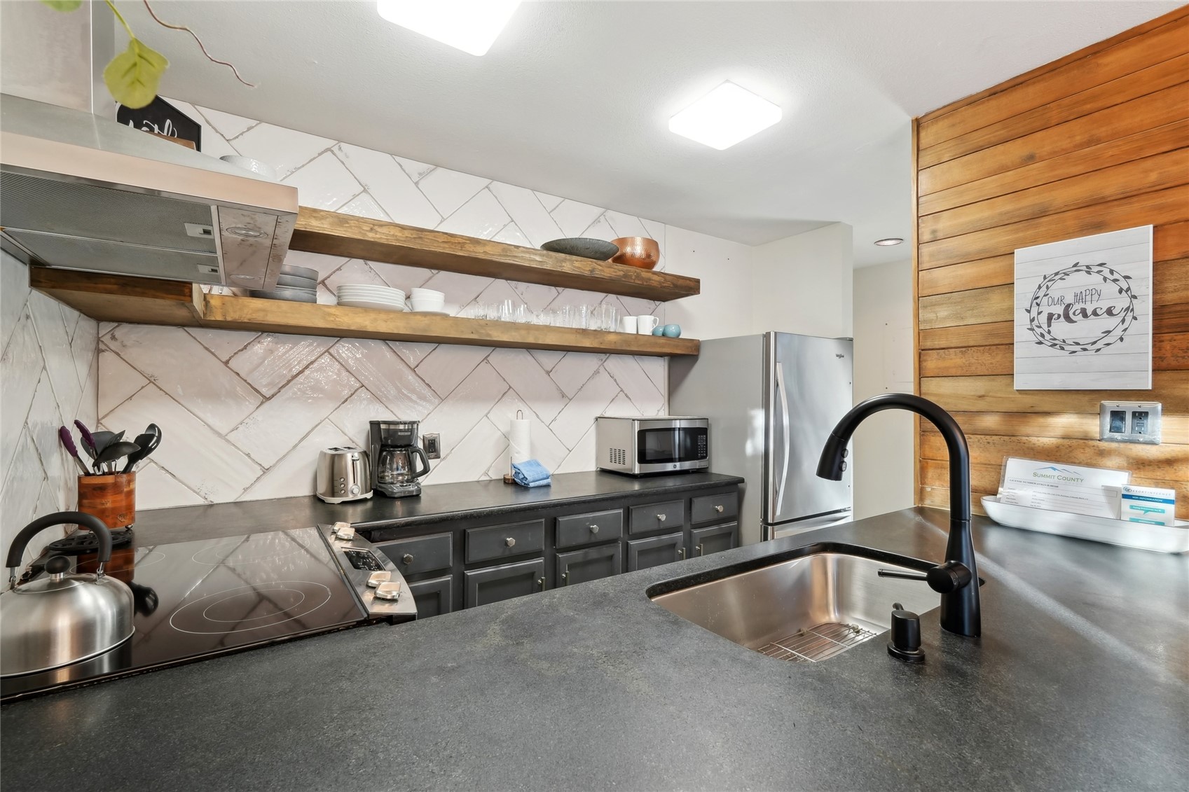 1937 Soda Ridge Road, Unit 1130 Dillon, CO 80435 - Photo 12 of 23 a kitchen with stainless steel appliances granite countertop a sink a stove and white cabinets next to a window