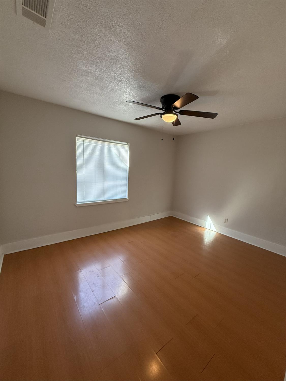 405 Colorado Avenue Modesto, CA 95351 - Photo 20 of 33 an empty room with a ceiling fan and window