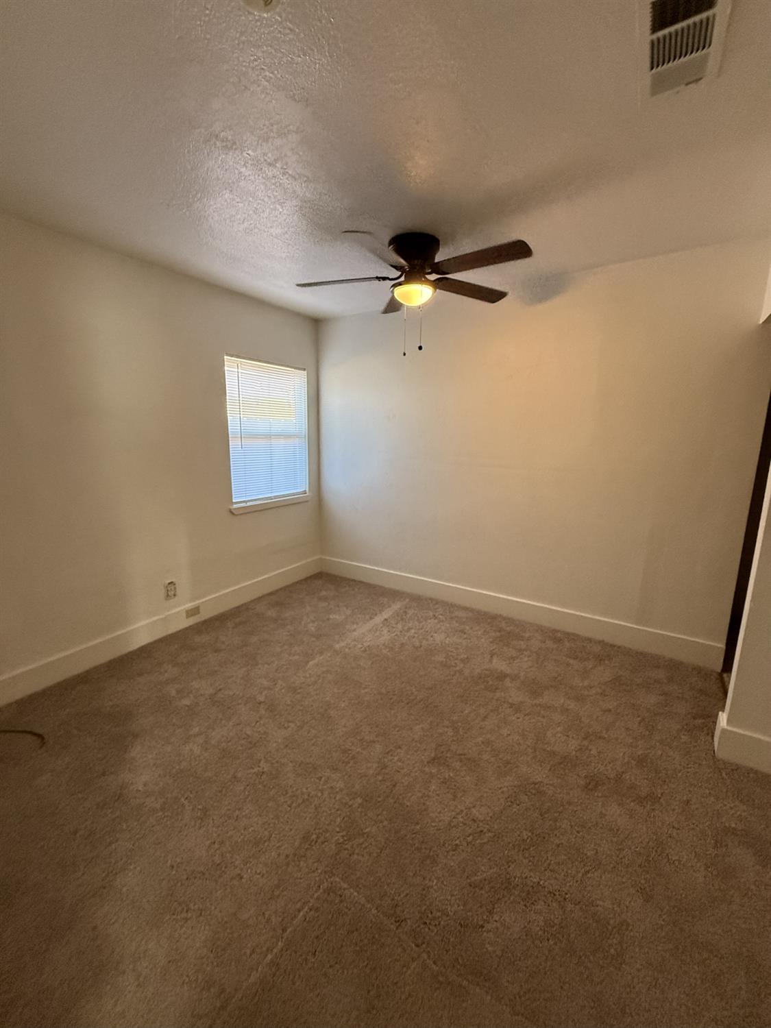 405 Colorado Avenue Modesto, CA 95351 - Photo 21 of 33 an empty room with windows and fan