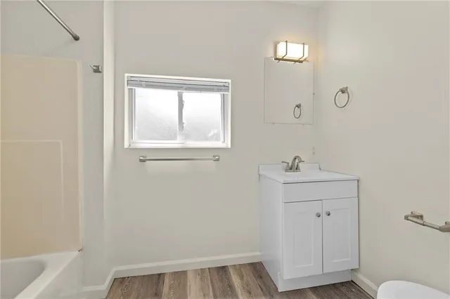 a view of bathroom with a sink window and wooden floor