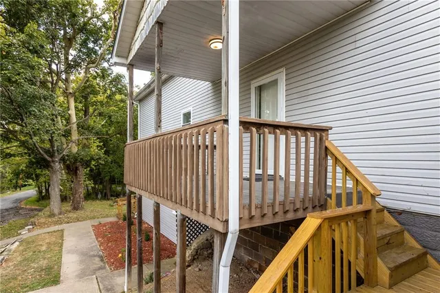 a view of balcony with wooden floor and fence and a trees