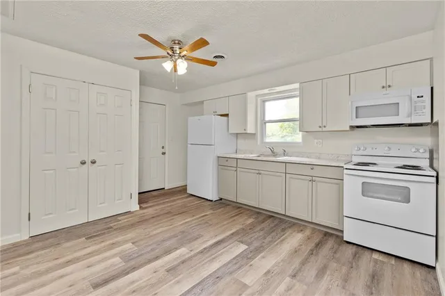a kitchen with cabinets stainless steel appliances and a window