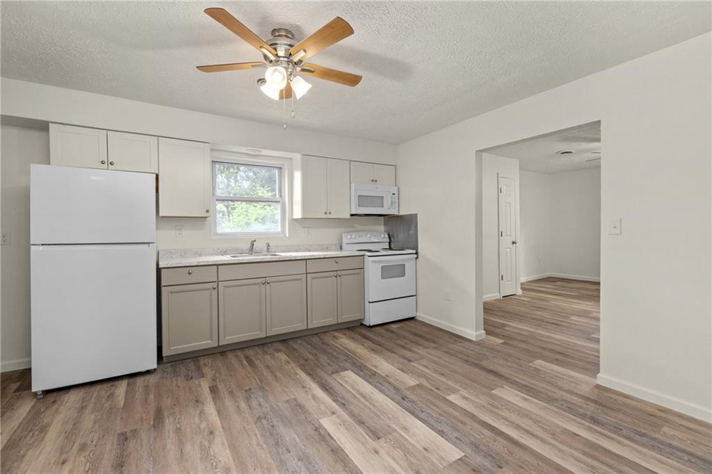 390 Highway 30, Unit B Imperial, PA 15126 - Photo 5 of 13 a kitchen with a refrigerator a sink and dishwasher with wooden floors