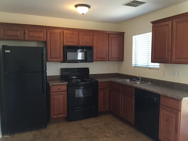 a kitchen with granite countertop wooden cabinets and a stainless steel appliances