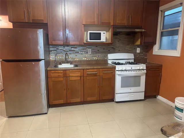 a kitchen with a stove top oven cabinets and a refrigerator