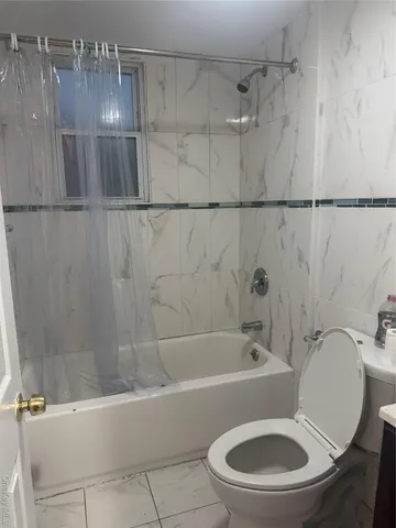 a white toilet sitting next to a bath tub and shower