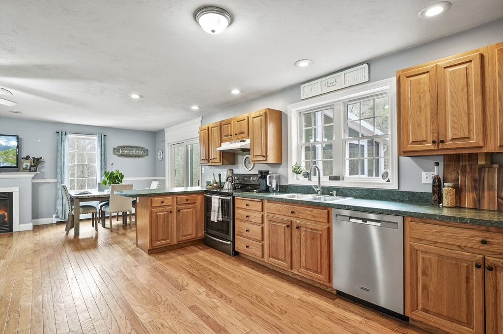 173 Oakham Road North Brookfield, MA 01535 - Photo 4 of 30 a large kitchen with kitchen island granite countertop wooden floors and white stainless steel appliances