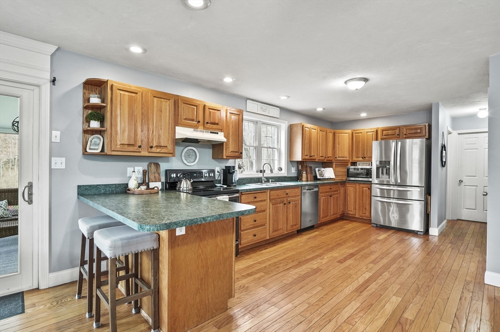 173 Oakham Road North Brookfield, MA 01535 - Photo 5 of 30 a kitchen with stainless steel appliances granite countertop a sink a stove a refrigerator cabinets and wooden floor