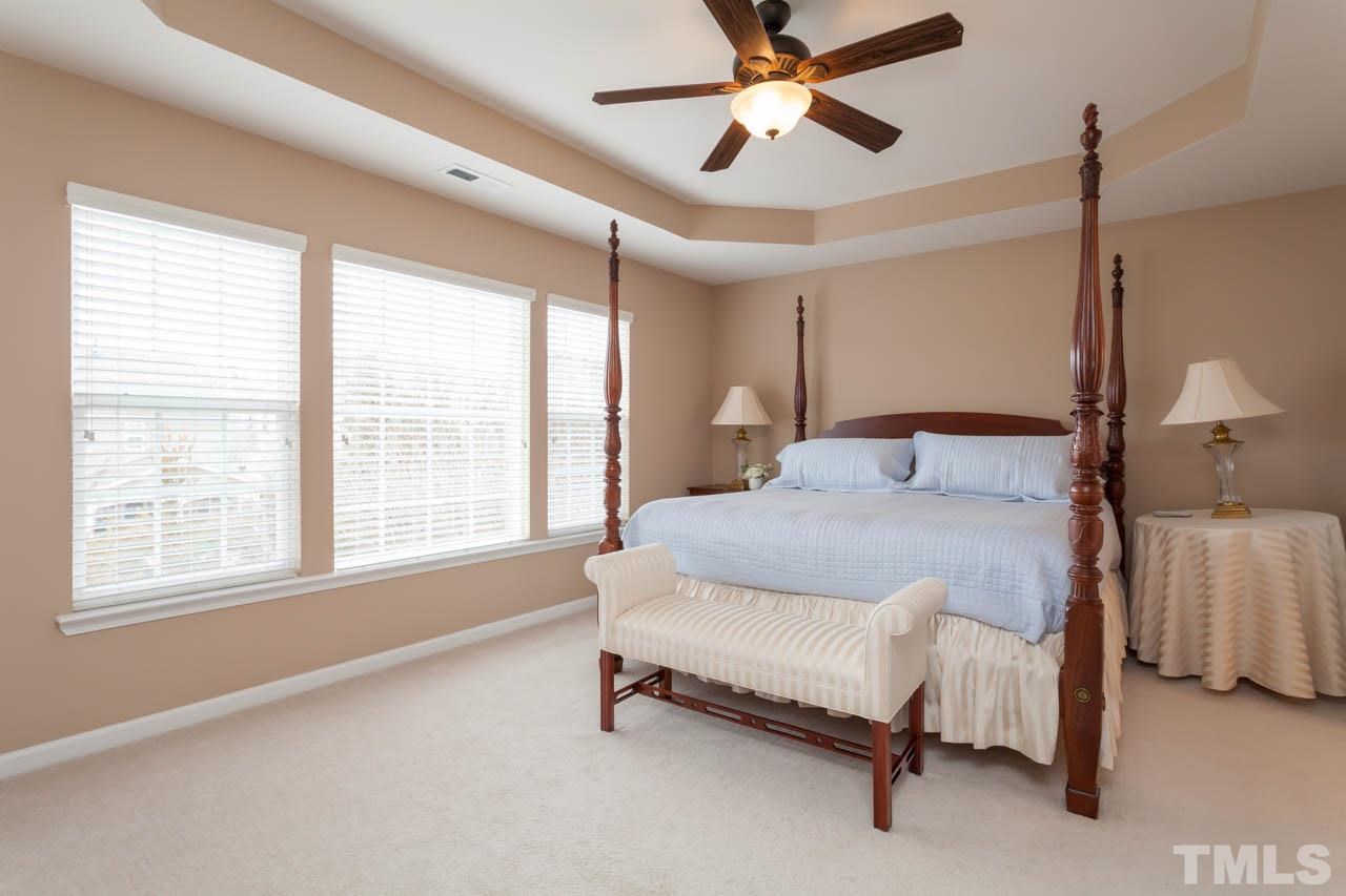 7472 Silver View Lane Raleigh, NC 27613 - Photo 14 of 25 a bedroom with a bed and a chandelier