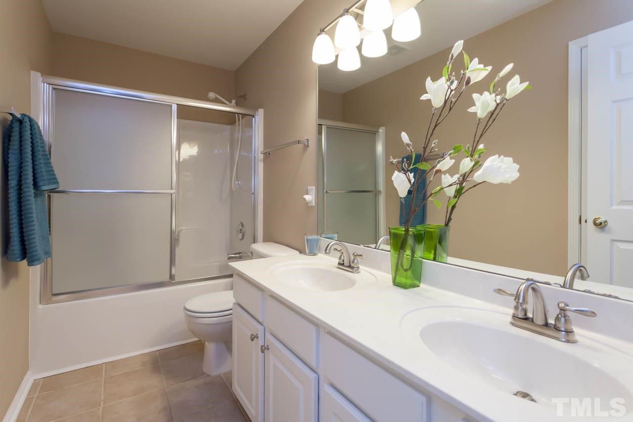 7472 Silver View Lane Raleigh, NC 27613 - Photo 19 of 25 a bathroom with a double vanity sink mirror and toilet