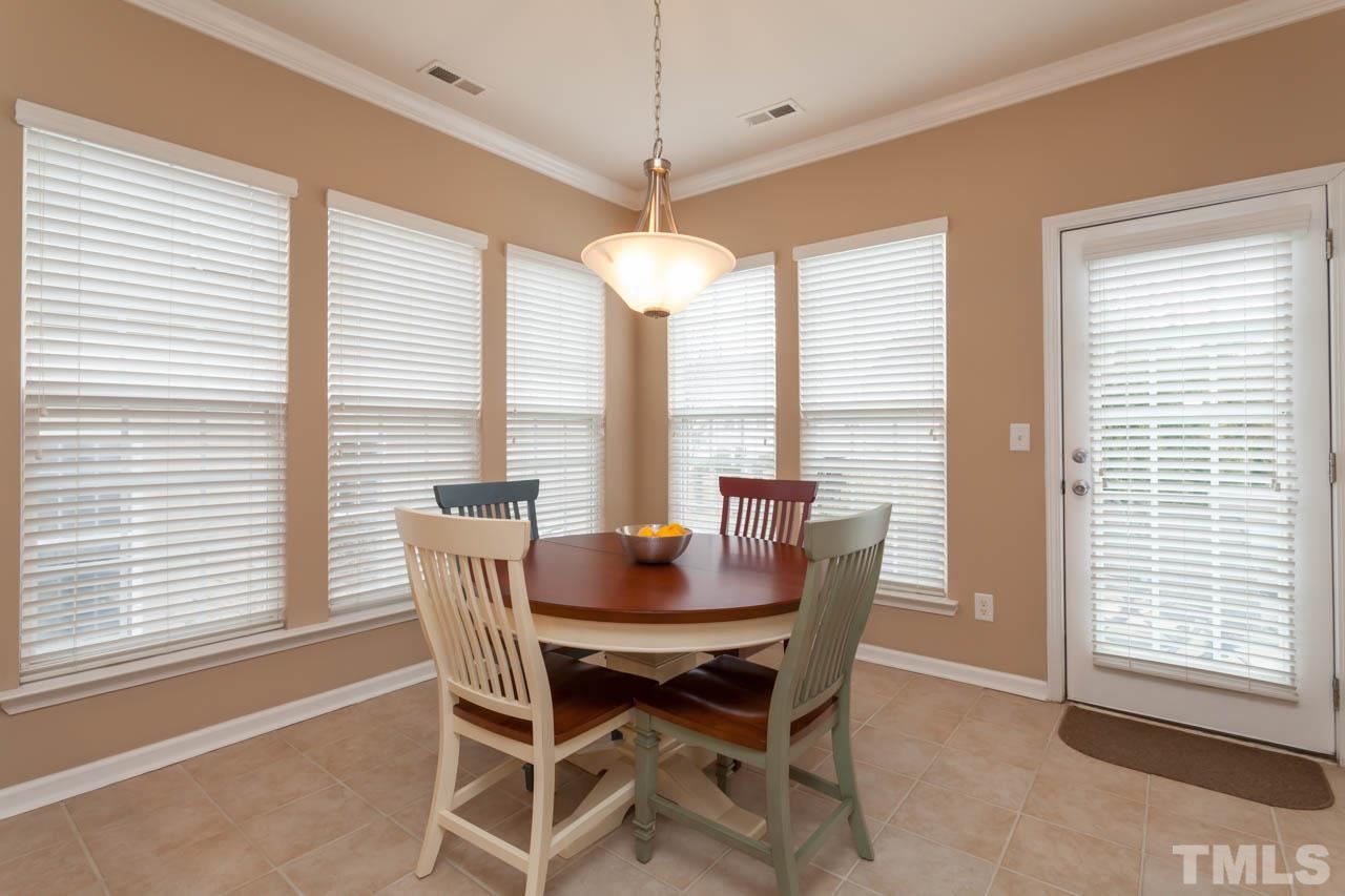 7472 Silver View Lane Raleigh, NC 27613 - Photo 4 of 25 a dining room with furniture a chandelier and wooden floor