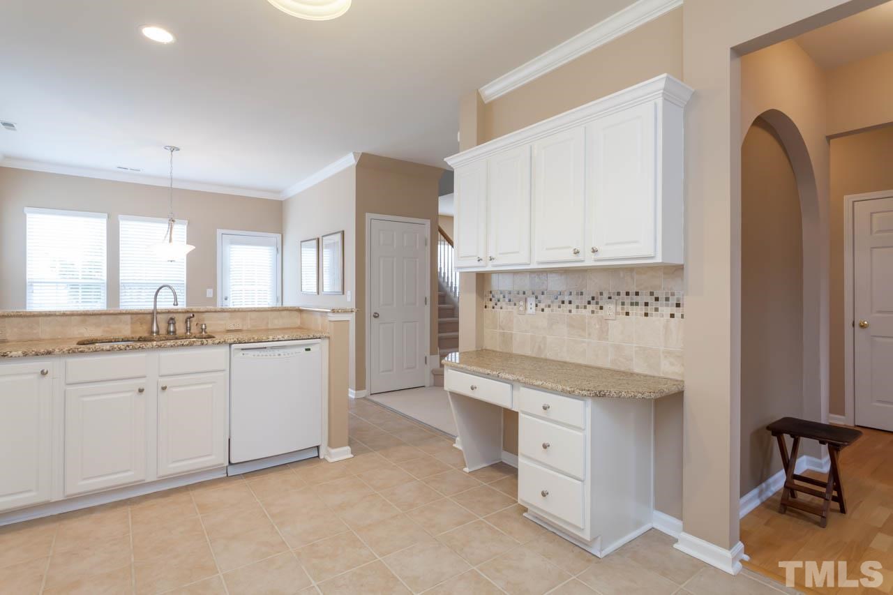 7472 Silver View Lane Raleigh, NC 27613 - Photo 7 of 25 a kitchen with granite countertop white cabinets and white appliances