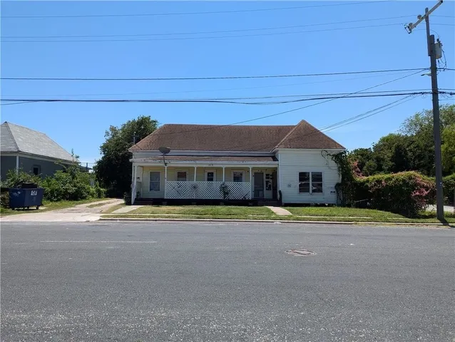 a front view of a house with a yard and trees